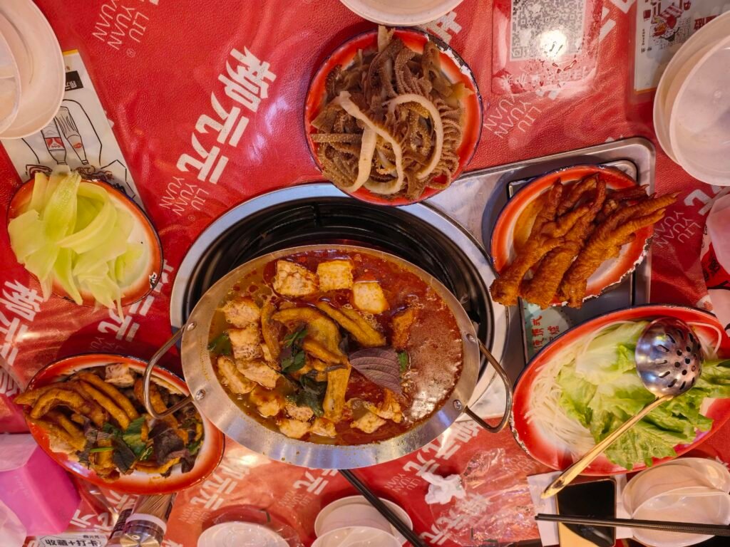 Table spread at Liu Yuan Yuan restaurant in Liuzhou with a central duck-foot hot pot and side dishes