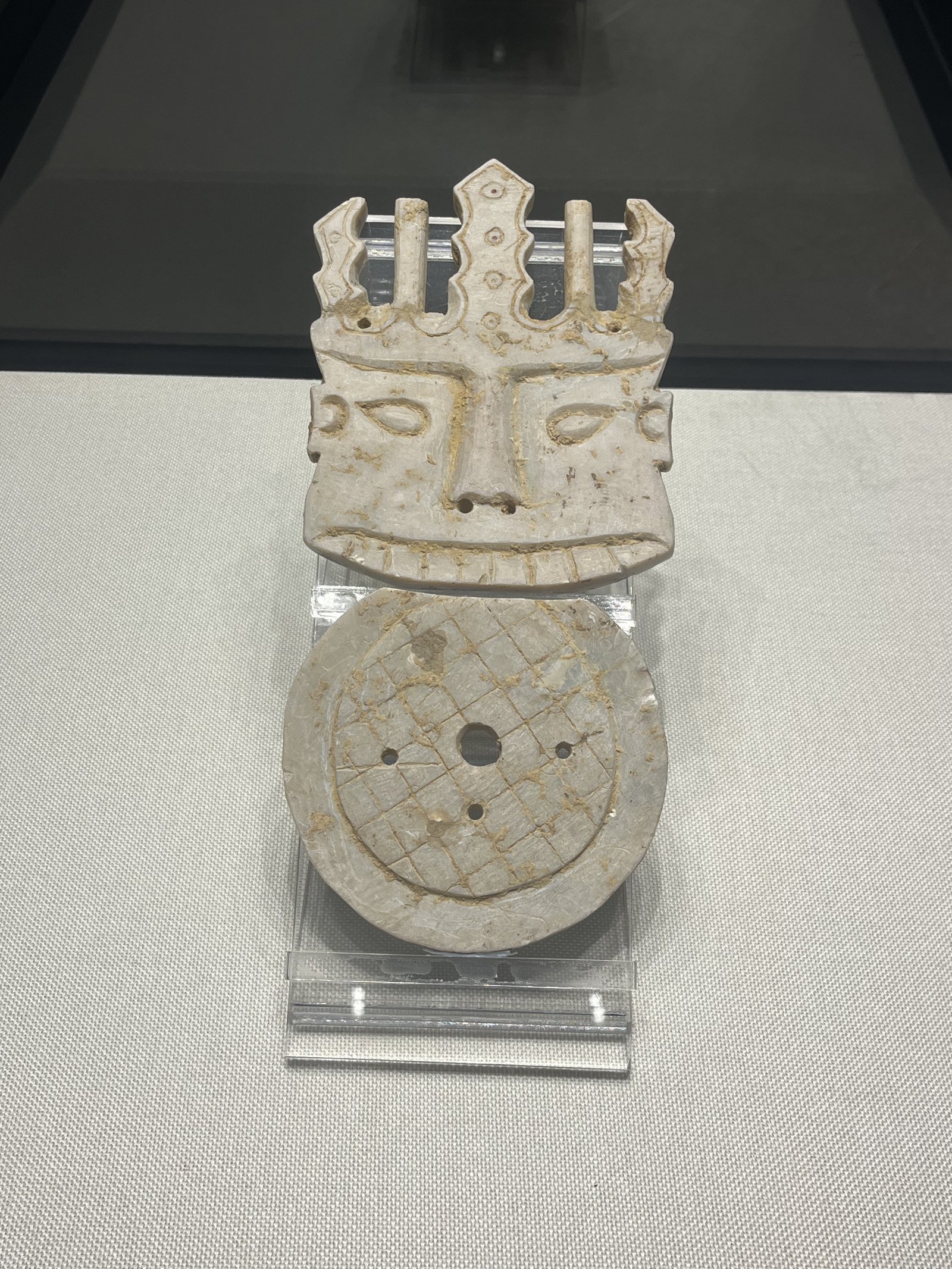 A carved stone face displayed in a case at Liuzhou Museum